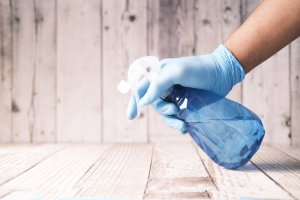 Image of gloved hand with spray bottle